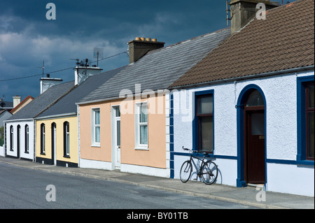 Straßenszene Pastell gemalt Reihenbungalows und Fahrrad in Kilkee, County Clare, Railway Road, westlich von Irland Stockfoto