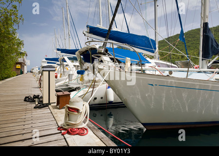 Boote vertäut neben der Anlegestelle in Marigot Bay, St. Lucia. Stockfoto