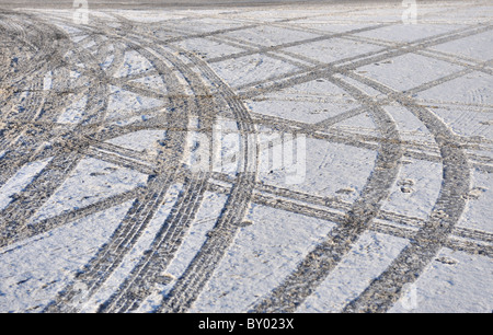 Reifenspuren auf verschneiten und vereisten Straße links Stockfoto