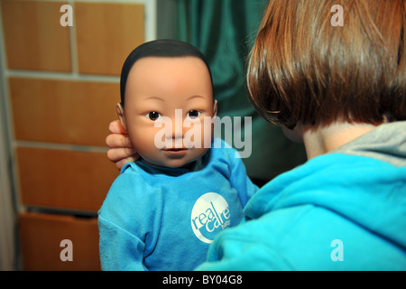 Ein 13 Jahres altes Mädchen kümmert sich eine "echte Pflege-Baby" für das Wochenende im Rahmen eines Schulprojektes, Teenager-Schwangerschaften zu verhindern Stockfoto