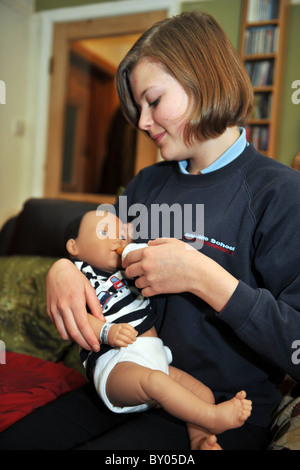 Ein 13 Jahres altes Mädchen kümmert sich eine "echte Pflege-Baby" für das Wochenende im Rahmen eines Schulprojektes, Teenager-Schwangerschaften zu verhindern Stockfoto