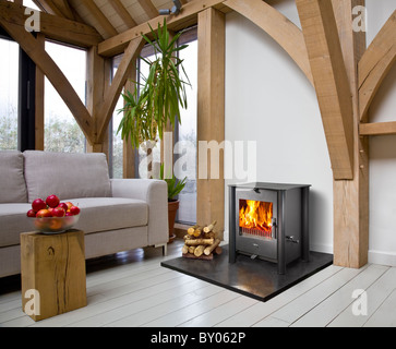 Eine Esse Holzverbrennung Herd in einer Eiche gerahmt modernes Haus. Stockfoto