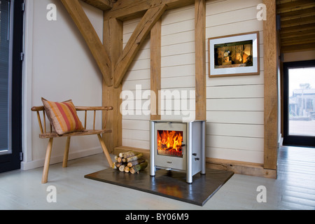 Eine Esse Holzverbrennung Herd in einer Eiche gerahmt modernes Haus. Stockfoto