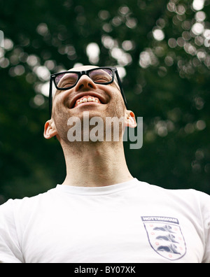 Ein junger Mann lächelnd, Brillen-und ein Retro-England Fußball-Trikot. Stockfoto