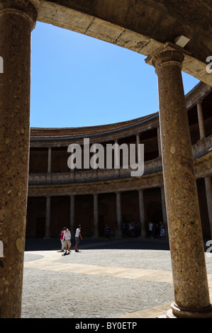 Säulen im Palacio de Carlos V mit Besucher, die Schatten vor der Sonne an einem heißen und sonnigen Tag an der Alhambra, Granada Stockfoto