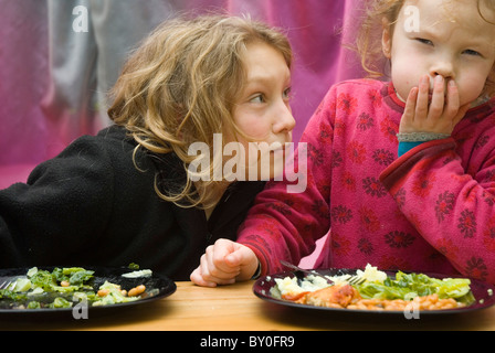 Zwei junge Mädchen, die sich weigern ihr Gemüse Stockfoto