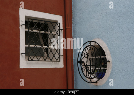 Zwei Windows - eine Runde, ein Quadrat - bunt bemalte Häuser auf der Insel Burano, in der Lagune von Venedig Stockfoto