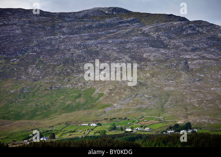 Häuser am Fuße des Maumturk-Gebirges in der Nähe von Aussparung in Connemara, County Galway, Irland Stockfoto