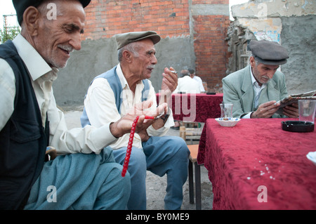 Drei ältere kurdische Männer tragen Hüte und unterhalten sich gemeinsam im Freien in der Stadt Diyarbakir im Südosten Anatoliens in der Türkei. Stockfoto