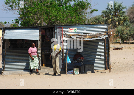 Kunden in einem täglichen Bedürfnisse Geschäft gemacht aus Wellblech in einem afrikanischen Dorf, Botswana Stockfoto