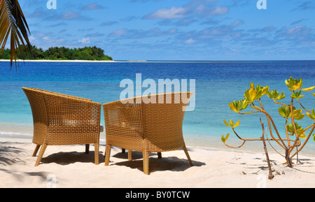 Zwei Stühle am Strand mit Insel im Hintergrund Stockfoto