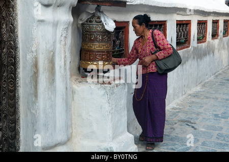 Tibetische Pilger dreht eine Gebetsmühle an der tibetisch-buddhistischen Stupa von Boudhanath in Kathmandu. Stockfoto