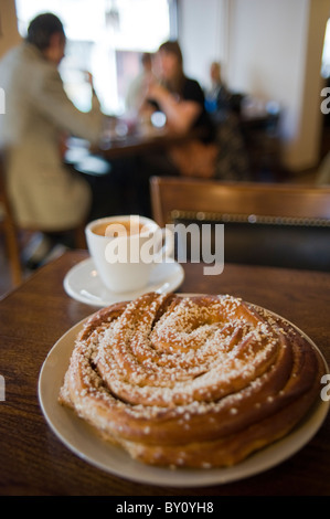 Innenraum des Café Husaren im Stadtteil Haga, Göteborg, Schweden. Ein großer traditioneller schwedischer Zimtkuchen (Kanelbullar) und Kaffee Stockfoto