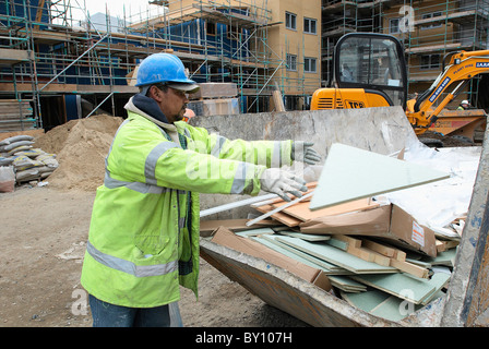 Bauarbeiter laden überspringen vor Ort mit Materialien für das recycling - Müll Trennung. Stockfoto