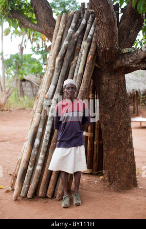 MECEBURI FOREST RESERVE, in der Nähe von NAMPULA, Mosambik, Mai 2010: Holz Pfosten für den Bau auf Verkauf außerhalb eines Dorfbewohners Haus. Stockfoto