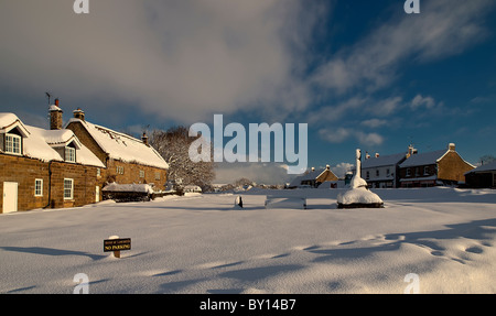 Ansicht von Goathland zeigt Geschäfte auf dem Land und Kriegerdenkmal im Tiefschnee Stockfoto