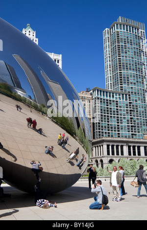 Besucher betrachten ihre Reflexion in der Cloud Gate Skulptur befindet sich an der AT&T Plaza im Millennium Park, Chicago, Illinois. Stockfoto