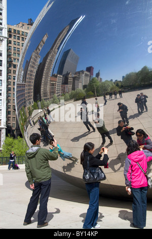 Besucher betrachten ihre Reflexion in der Cloud Gate Skulptur befindet sich an der AT&T Plaza im Millennium Park, Chicago, Illinois. Stockfoto