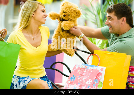 Porträt von glücklicher Mensch einen Teddybären zu ihrer Freundin im Shop geben Stockfoto