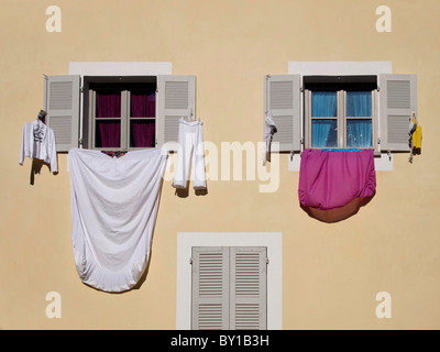 Bettwäsche und Kleidung trocknen hängen aus den Fenstern eines Hauses in einer Straße im Süden Frankreichs Stockfoto