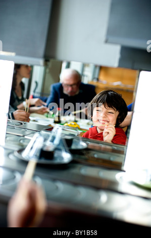 Fünf Jahre altes Kind im Westen mit Stäbchen im Sushi-restaurant Stockfoto