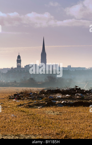 Eine entfernte Stadtzentrum von Limerick Skyline mit Müll in der Nähe von einem heruntergekommenen Wohnsiedlung im Vordergrund. Stockfoto