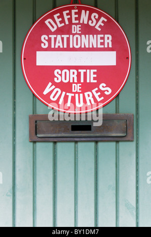 Französisch "Defense De Stationner - Sortie De Voitures" (No Parking - Auto Ausfahrt) Garagentore anmelden. Stockfoto