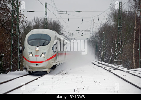 Deutsche Eisenbahn Intercity Express (ICE) läuft durch Schnee auf der Hauptstrecke zwischen Köln und Dortmund, Deutschland. Stockfoto
