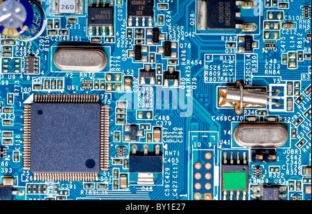 Nahaufnahme Foto von Mikrochips und mikroelektronischen Komponenten auf einer blauen Platine Stockfoto