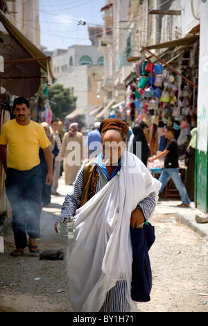 Tripoli, Libyen; Eine libysche Mann in traditioneller Kleidung Räucherstäbchen rauchte eine Zigarette und tragen durch den "Souk" des alten Stockfoto
