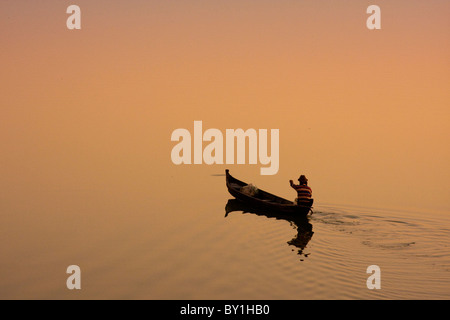 Myanmar, Burma, Amarapura. Ein Fischer bei Sonnenaufgang, Amarapura über Taungthaman See paddeln. Stockfoto
