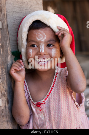 Myanmar, Burma, Mrauk U. junge Mädchen aus dem Dorf mit Weihnachtshut, ihr Gesicht verziert mit Thanaka, eine lokale Sonnencreme gemacht Stockfoto