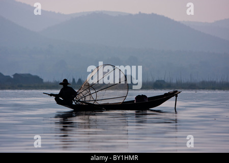 Myanmar, Burma, Lake Inle. Ein Intha Fischer mit seinem traditionellen konischen Net ruhig zusehen, für Fische in den Gewässern des Stockfoto