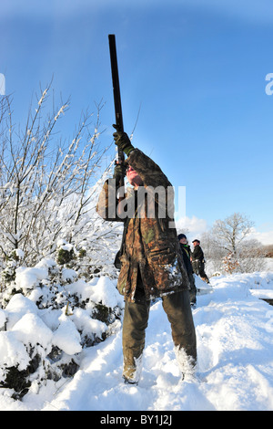 Mann, der Vögel in verschneiten Umgebung schießt Stockfoto