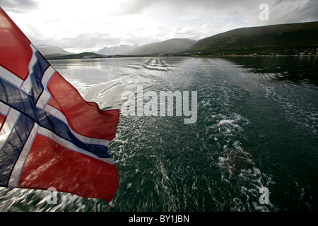 Norwegen, Tromso Region an einem Sommertag durch die norwegischen Fjorde, von der Hafen von Tromsø - eine norwegische Flagge segeln Stockfoto