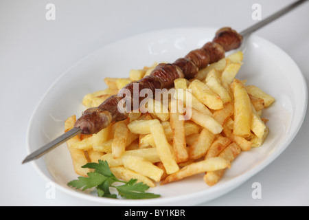 Char gegrillte Hühnerherzen Schaschlik-Spieß mit Pommes frites Stockfoto