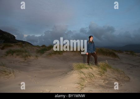 Walker am Strand von Barmouth, Wales am Ende des Weges Mawddach Stockfoto