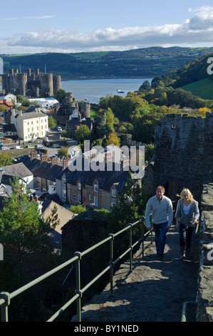 UK, Nord Wales; Conwy. Ein paar genießen Sie den Spaziergang entlang der alten befestigten Stadtmauern mit der Stadt, Burg und Conwy River Stockfoto