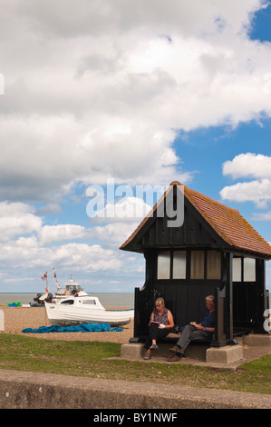 Ein paar entspannen Sie direkt am Meer im Sommer in Aldeburgh, Suffolk, England, Großbritannien, Uk Stockfoto