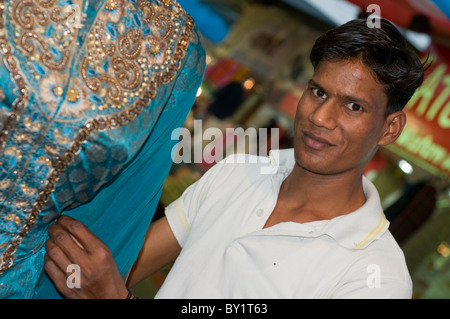 Ein Schneider tendenziell einen Sari auf einem Marktstand in Bhopal, Indien Stockfoto