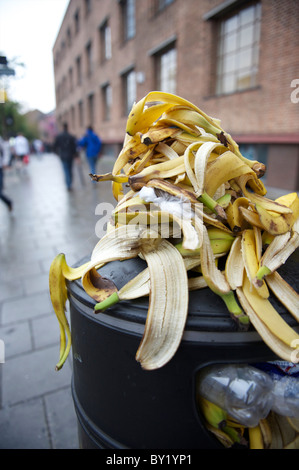 Ein Haufen von Banane schält bildet eine Pyramide auf einen Abfalleimer von Läufern, die Lagerung bis zur schnellen Energie in der Nähe der Startlinie vor Stockfoto