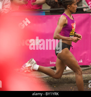 Eine Elite Frau Läufer Rennen vorbei an 25 Meile Markierung beim London-Marathon. Mehr als 36.000 Läufer nahmen an der 2010 Virgin London Stockfoto