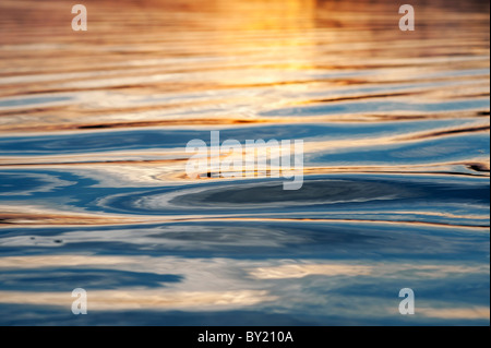 Abstrakte goldene Wasser plätschert bei Sonnenuntergang an einem See in Indien Stockfoto