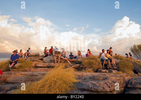 Australien, Northern Territory, Kakadu-Nationalparks Ubirr.  Eine Menschenmenge versammelt auf den Sonnenuntergang über Kakadu auf der Nadab festgelegt Stockfoto