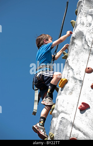 England, Devon, Woolacombe. Junge Skalierung eine künstliche Kletterwand Woolacombe Bay Holiday Park. (MR) Stockfoto