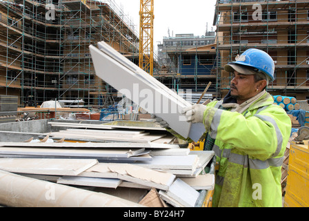 Bauarbeiter laden überspringen vor Ort mit Materialien für das recycling - Müll Trennung. Stockfoto