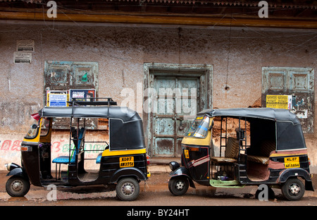 Indien, Cochin. Tuk-Tuks parkte vor einer alten Mauer in Cochin. Stockfoto