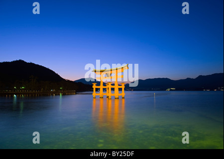 Asien, Japan, Honshu, Hiroshima-Präfektur, Insel Miyajima, schwimmenden Torii Tor beleuchtet bei Dämmerung Stockfoto