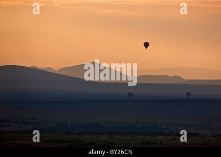 Tagesanbruch über Masai-Mara als Heißluft Ballons Drift über die Ebenen. Stockfoto
