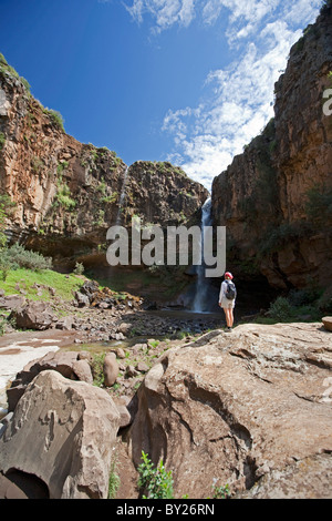 Lesotho, Malealea. Als Tourist sieht an einem Wasserfall während auf einer Wanderung von Malealea. HERR Stockfoto